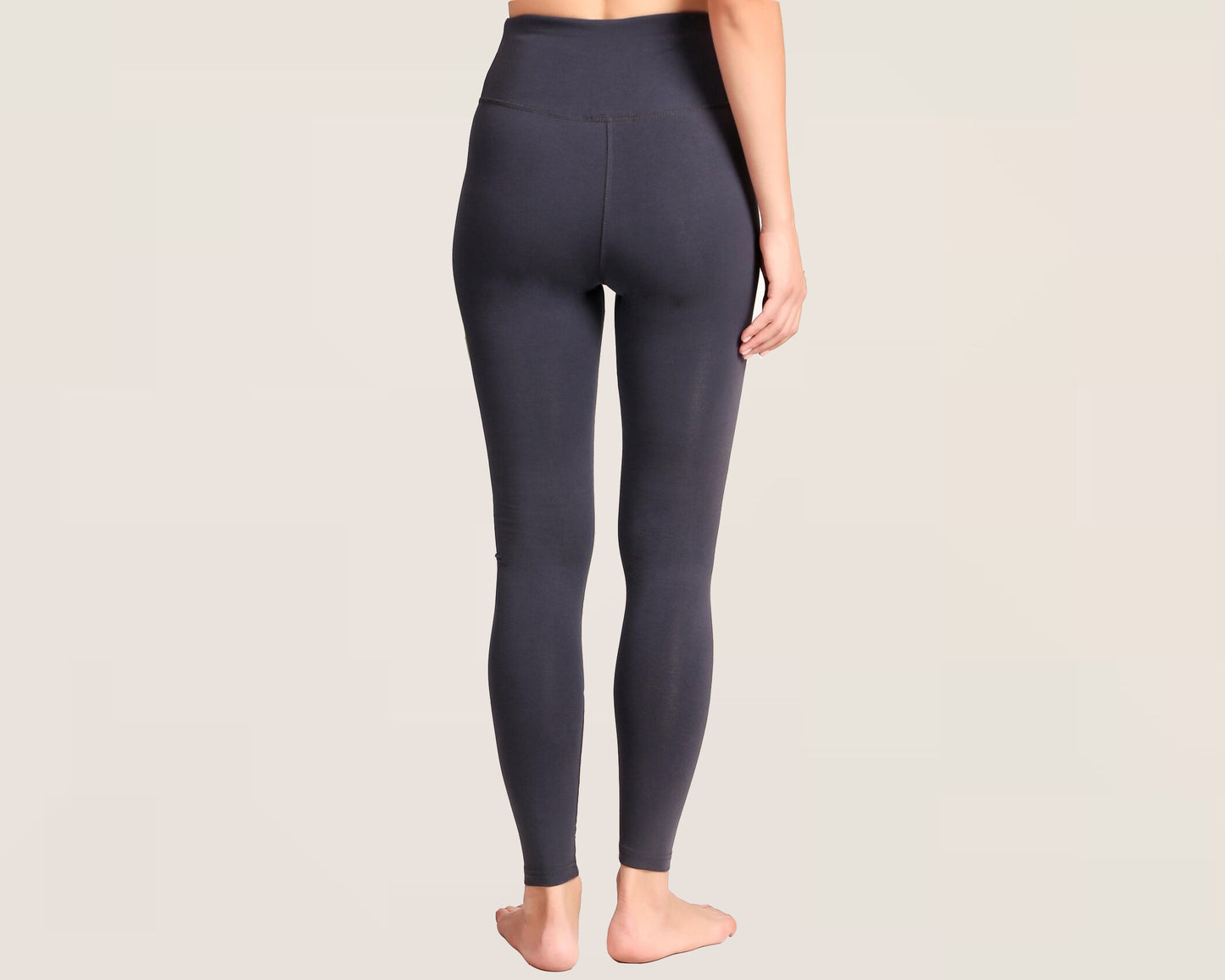 Woman wearing high-waisted charcoal gray leggings, shown from the back against a neutral background.