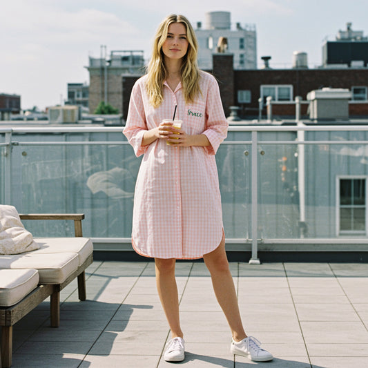 Woman on a sunny rooftop wearing a pink checkered nightshirt with Grace vinyal printing in green script