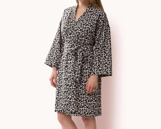Woman wearing a leopard print fleece robe with a waist tie.