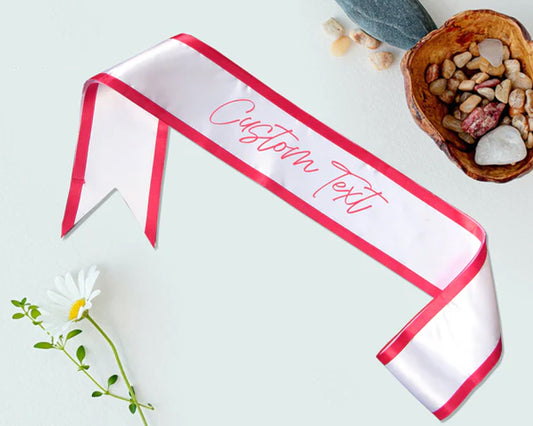 White satin sash with red trim and customizable text, ideal for special events, parties, and celebrations.
