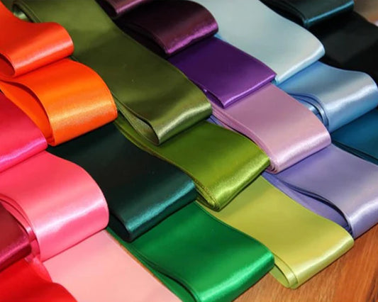 Colorful satin fabric rolls neatly arranged.