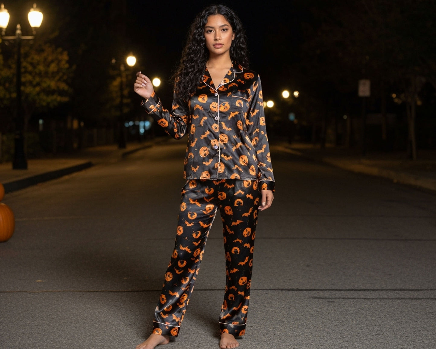 Woman wearing a Halloween-themed pajama set on a street at night.