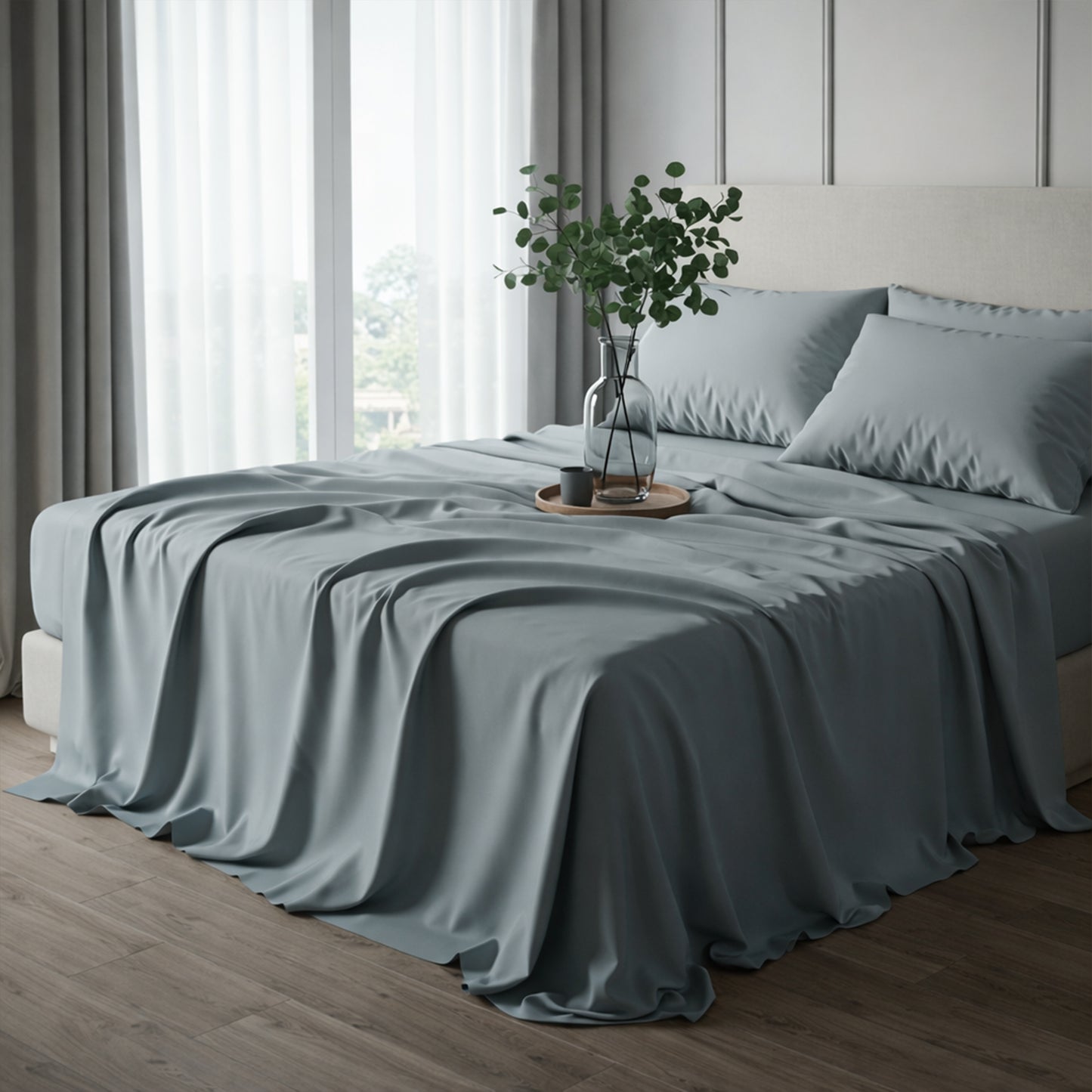 Soft slate gray-blue satin bedding styled with a green eucalyptus branch