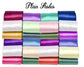 A neatly stacked collection of shiny, rolled satin ribbons in various vibrant colors, arranged in rows.