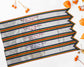 A set of silver award sashes with rainbow borders, embroidered with names and titles, displayed with orange berries on a white background.