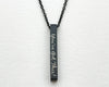 A black bar necklace with an uplifting engraved message on a matching chain.