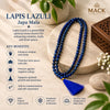 A blue beaded Lapis Lazuli Japa mala necklace with a blue tassel is displayed on a beige stone pedestal. The image includes marketing text, icons, and the brand logo 'MACK Spiritual Collection' on a warm beige background with decorative green leaves and a wooden box.