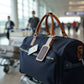 Blue duffel bag with brown leather straps in an airport setting