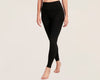Woman wearing high-waisted black leggings against a neutral background.