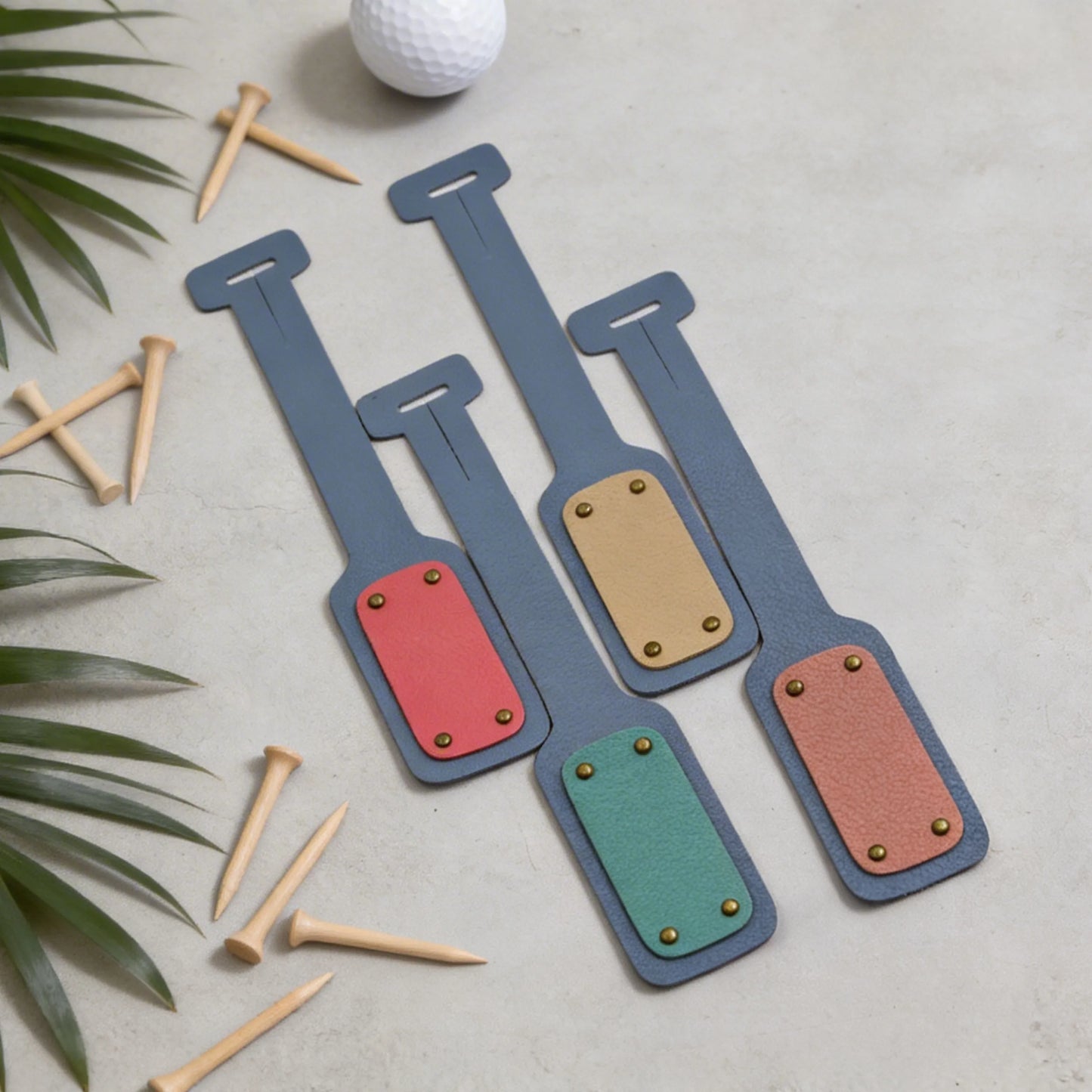 Colorful golf bag tags on a light surface with golf tees and a ball.