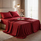 Deep ruby red satin sheets styled on a classic ornate gold bed frame