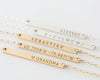 Personalized gold and silver bar necklaces with engraved names, coordinates, and messages