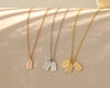 Three delicate tag necklaces in rose gold, silver, and gold with engraved names, displayed on a soft beige surface.