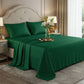 Luxurious emerald green satin sheets styled on a cream headboard with white lilies