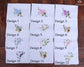 Set of embroidered handkerchiefs with floral designs on a wooden surface