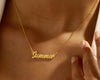 Gold nameplate necklace with "Summer" in cursive on a delicate chain.
