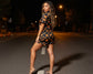 Woman in a Halloween-themed dress standing on a dark street at night.
