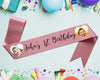 Pink ribbon with "John's 1st Birthday" and two baby photos in heart-shaped cutouts.