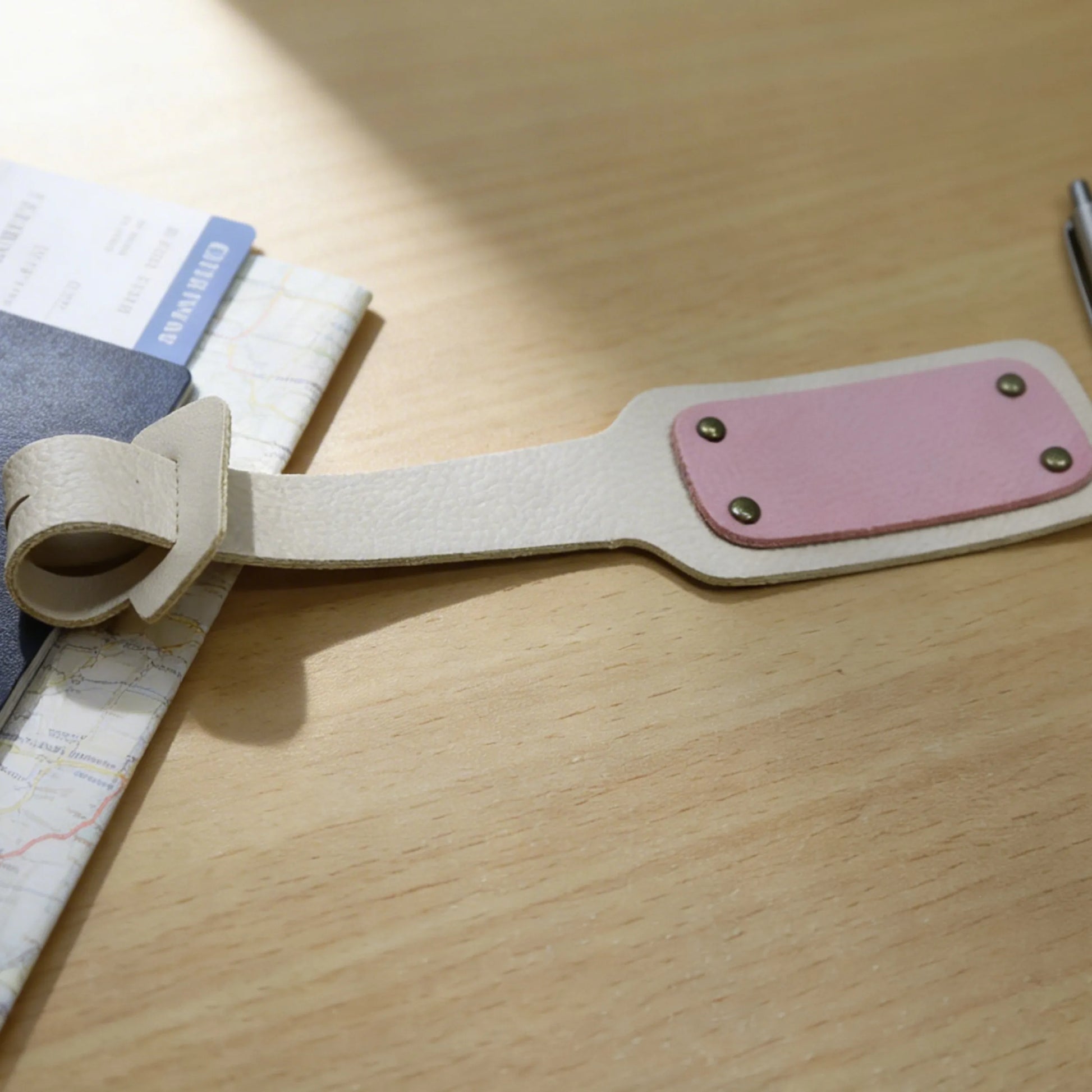 Leather strap with pink accent on a wooden surface