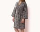 Woman wearing a leopard print fleece robe with a waist tie.