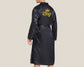 A male model wearing a black satin robe with "King" and a gold crown embroidered on the back. The robe features a smooth finish and a tie belt for a luxurious look.