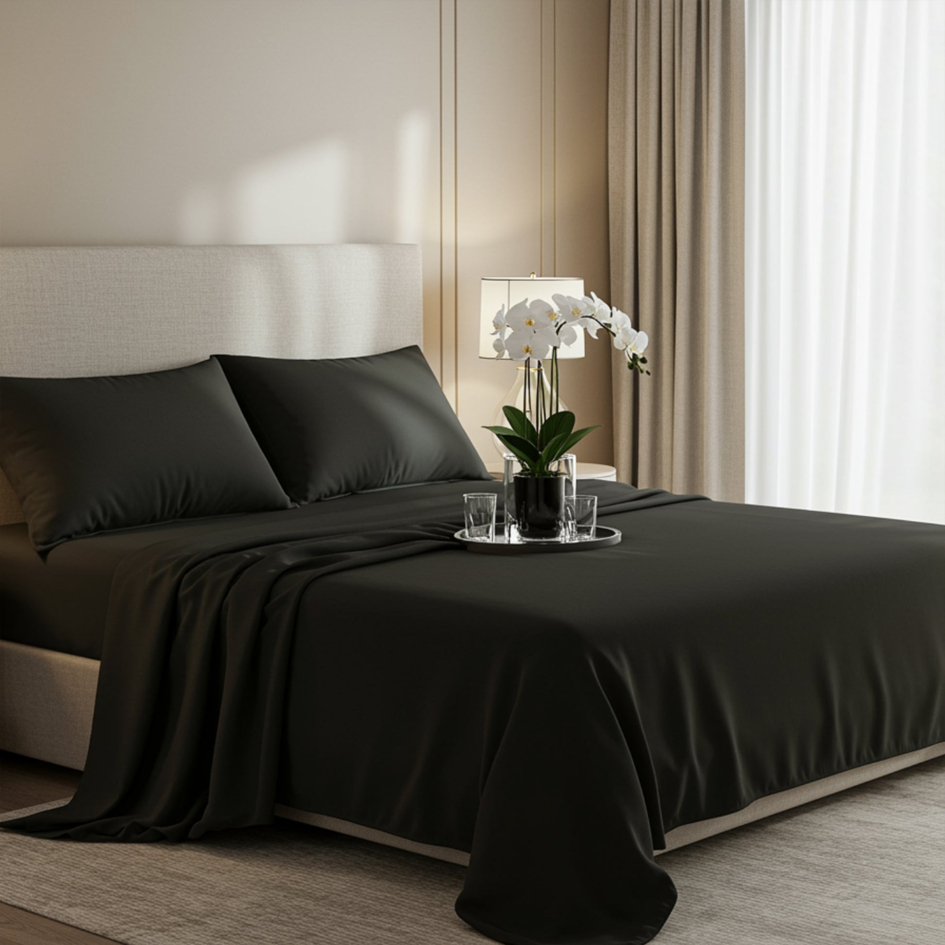 Premium black satin bedding set featuring a matching duvet cover and pillowcases on a modern bed