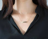 Custom gold bar necklace with name engraving and gemstone accent.