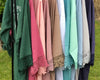 Colorful lace-trimmed robes hanging on a rack outdoors.