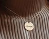 Elegant gold disc necklace with "louisa" engraved in stylish script, ideal for custom gifts.