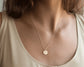 Round disc pendant with engraved letter "A".