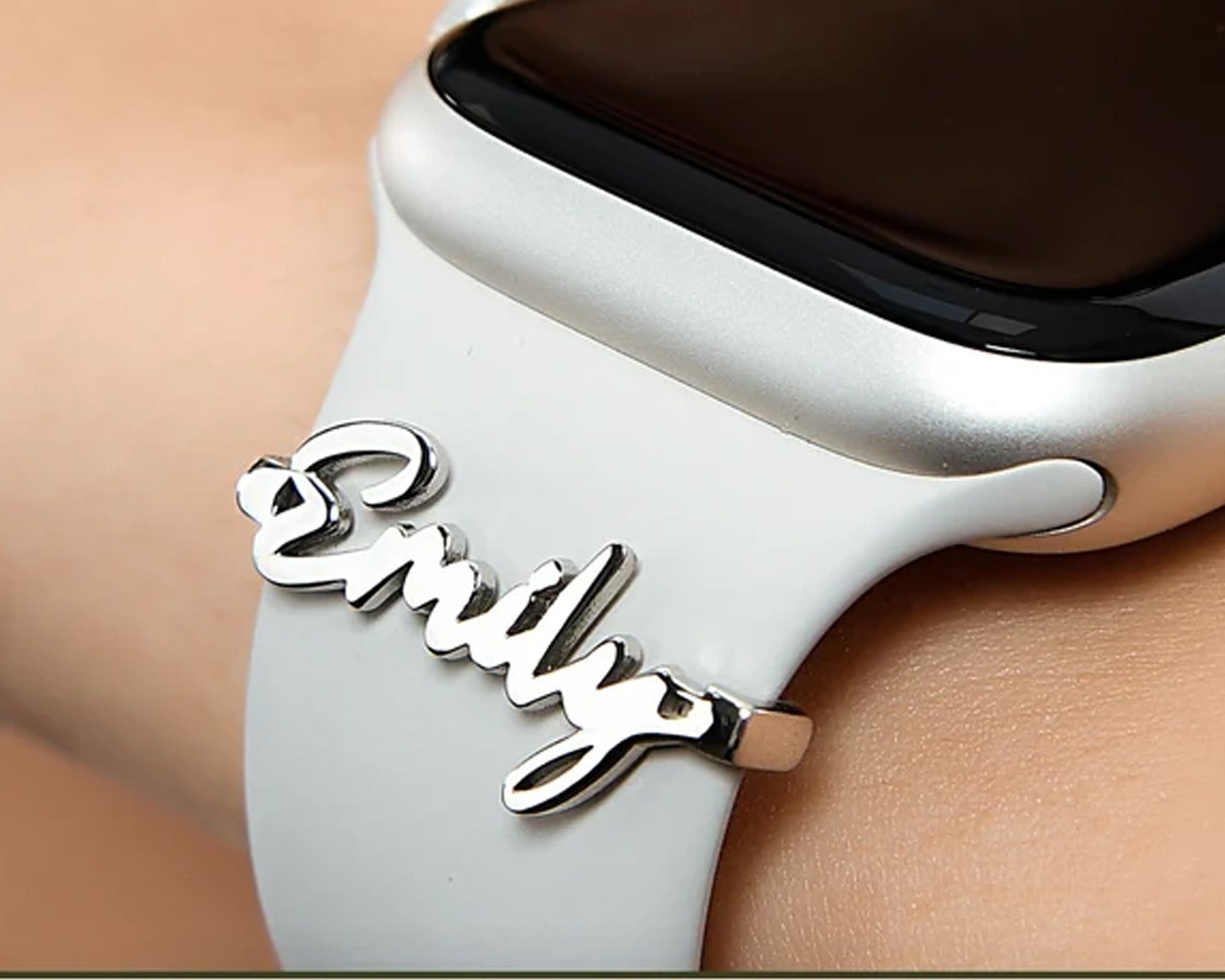 Custom name charm attached to an Apple Watch band, adding a stylish and personal touch.