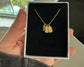 Gold name tag necklace in a gift box, featuring custom engravings.
