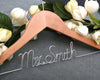 Wooden hanger with "Mrs. Smith" in silver wire, surrounded by white roses.