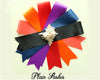 A collection of colorful plain sashes arranged in a fan shape with a seashell in the center.