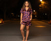Woman wearing a Halloween-themed pajama set on a street at night.