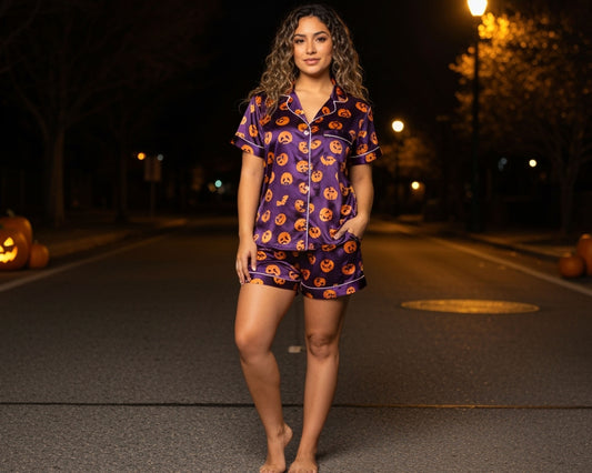 Woman wearing a Halloween-themed pajama set on a street at night.