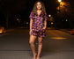 Woman wearing a Halloween-themed pajama set on a street at night.