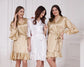 Elegant satin ruffle bridesmaid robes in champagne and white, perfect for wedding mornings and bridal parties.