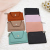 Set of small leather wallets in various colors on a textured surface with flowers.