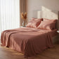 Luxury terracotta clay colored satin bedsheets on a modern bed with pampas grass decor