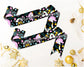 Black bridesmaid sash with colorful unicorns, rainbows, and floral patterns, featuring elegant white script text.