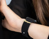 A delicate gold watch charm with a heart-shaped pendant, elegantly attached to a wristwatch, perfect for a sentimental gift.