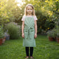 Child wearing cotton apron in garden