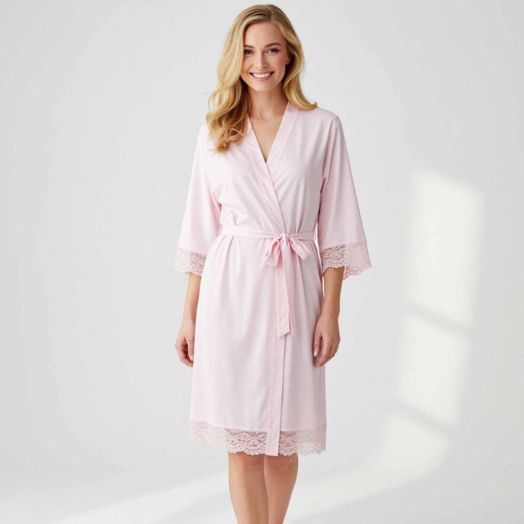 Woman wearing a pink robe with lace details on a white background