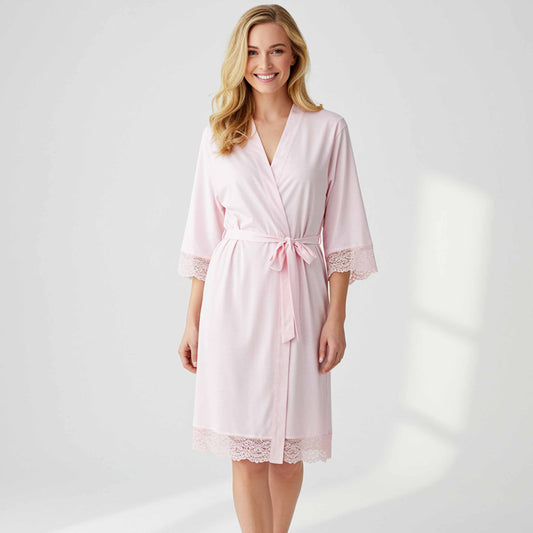 Woman wearing a pink robe with lace details on a white background