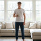 Man holding a mug in a living room with large windows