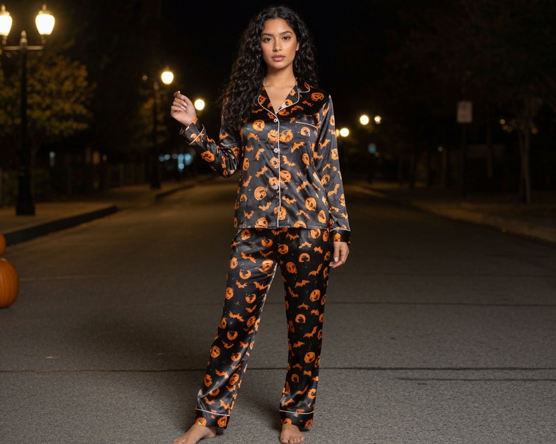 Woman wearing a Halloween-themed pajama set on a street at night.