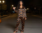 Woman wearing a Halloween-themed pajama set on a street at night.