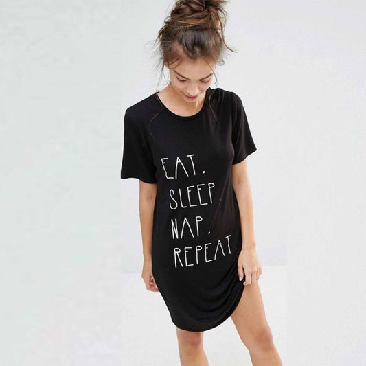 wearing a black t-shirt with 'EAT. SLEEP. NAP. REPEAT.' text on a white vinyl background