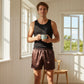 Man holding a mug in a bright room with large windows